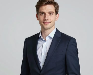 Portrait of a young, professional entrepreneur (Attmann Stefanou) in a modern navy suit, looking confident and approachable, clean studio lighting with a neutral background.