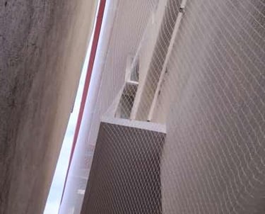 Close-up of a window securely covered with fine pigeon netting mesh.