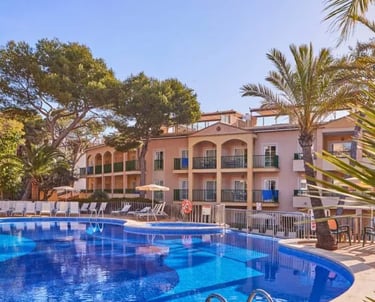 Swimming Pool Surrounded by Trees at Zafiro Cala Mesquida