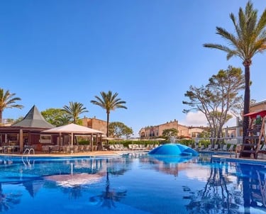 Large Swimming Pool with Palm Trees and Blue Sky at Zafiro Menorca