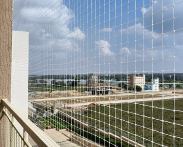 A close-up of a securely installed pigeon net on a sunny Chennai balcony.