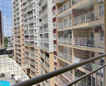 Close-up of a sturdy balcony pigeon net tightly fitted to a railing in a residential area.