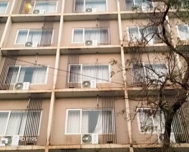 Technician carefully fitting anti-pigeon netting over a Koyambedu market stall.
