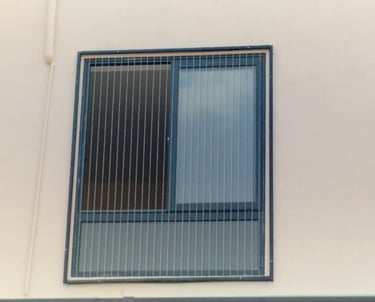 Close-up of a sleek invisible grill perfectly fitted on a balcony window in Egmore.