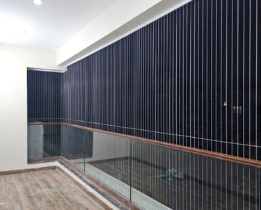 Technician from Arjilli Enterprises installing invisible grills on a window in Besant nagar.