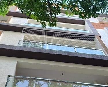 Close-up of a sleek invisible grill perfectly fitted on a Besant Nagar balcony.