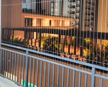 Technician from Arjilli Enterprises installing invisible grills on a residential balcony.