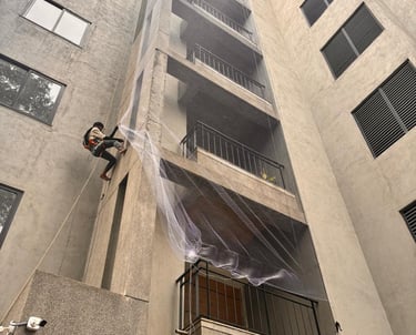 Close-up of a finely woven pigeon net tightly fitted on a Mumbai balcony railing.