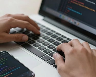 Close-up of hands typing on a modern laptop keyboard with a smartphone on the side showing code results. Professional, International / European workplace.