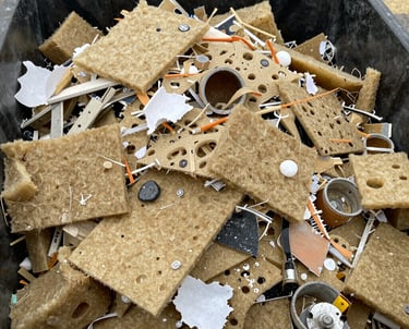 Construction debris and soil piled next to a Solidus rental container on a building site.