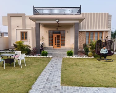 Modern luxury PG exterior with a stone path, green lawn, and comfortable outdoor patio furniture.