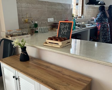 Modern white and wood sideboard in an open kitchen featuring a marble countertop and chalkboard menu.