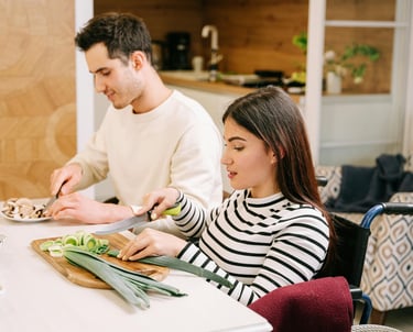 Support worker helping a participant prepare food in the kitchen