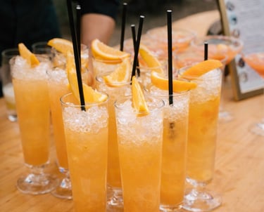 Refreshing orange cocktails with crushed ice and citrus slices at an outdoor bar.