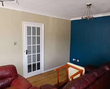 Corner of a furnished sitting room, with a cream wall, royal-blue wall, and white ceiling.