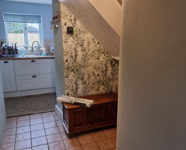 Botanical wallpaper covering a wall underneath a stairway, in a residential home.