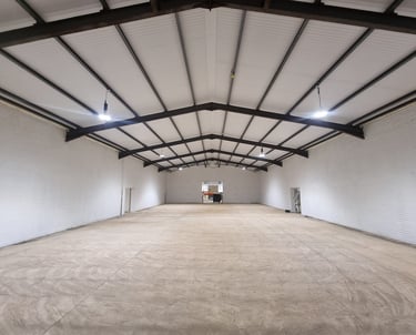 A large industrial unit, completely painted a pure-white with black detailing on the ceiling.