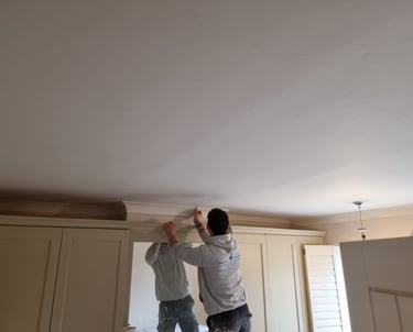 Bedroom ceiling coving in the process of being painted, above a wardrobe.