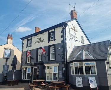 The painted-grey, brick exterior of a pub named The Anglers.