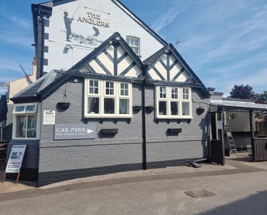 The painted-grey, brick exterior of a pub named The Anglers.