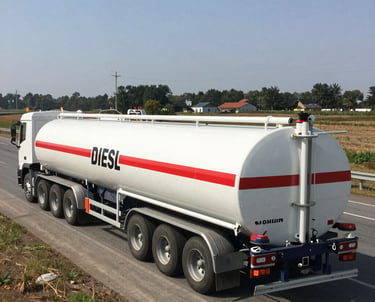 A modern fuel tanker truck on the highway during sunset.