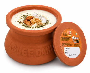 Aslee Matka Dahi fresh yogurt served in a traditional clay pot topped with almonds and walnuts.