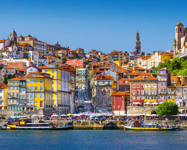 Colorful Ribeira district buildings and Rabelo boats on the Douro River in Porto, Portugal.