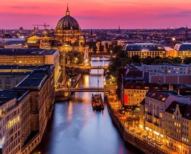 Berlin Cathedral and Spree River at sunset with a panoramic city skyline view in Germany.
