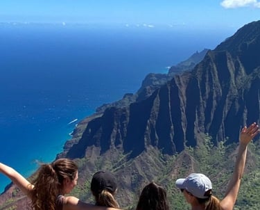 a group of fitness retreat guests posing at the top of a mountain