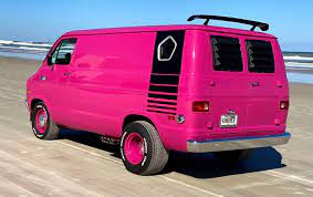 a pink van parked on the beach