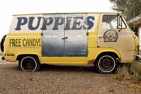 a yellow van with a sign that says puppies