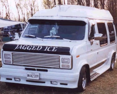 a white van parked in a field with a large tent