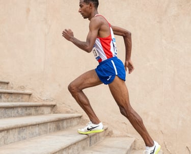 A runner lacing up shoes at dawn on a quiet Moroccan street.