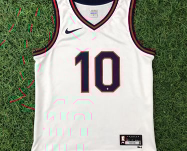 A young person wearing a vibrant jacket and sneakers, standing against a graffiti-covered wall.