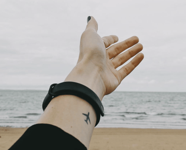 A person reaches a hand toward the ocean beach,  a helping hand to folks looking for home care