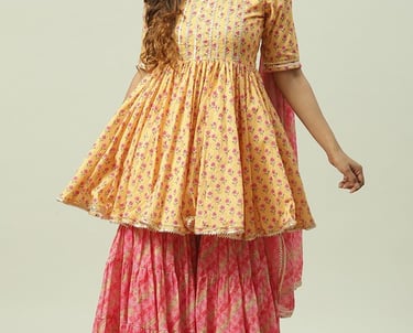 Woman wearing a yellow and pink floral print Anarkali kurta with matching sharara pants and dupatta.