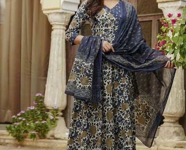 Woman wearing a floral printed indigo cotton Anarkali suit with a matching dupatta and palazzo pants.