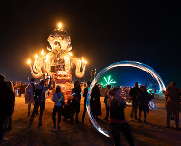 A fire-breathing octopus art car and light dancers in the desert night.