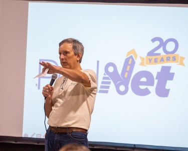 Man with a microphone in front of a presentation screen
