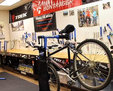 Photo of a bike on a bike mount like it is being worked on, with tools in the background