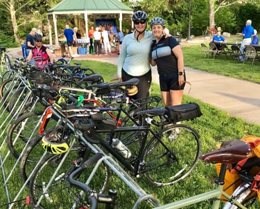 Two women posed in front of a large row of parked bikes