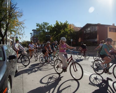 A group of around 10 women riding bikes on a street in downtown Columbia