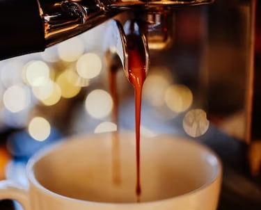 a cup of coffee being poured into a cup of coffee