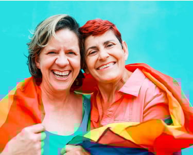 two women in colorful clothing smiling and hugging each other