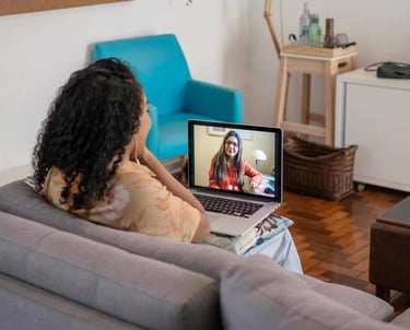 a woman sitting on a couch with a laptop computer