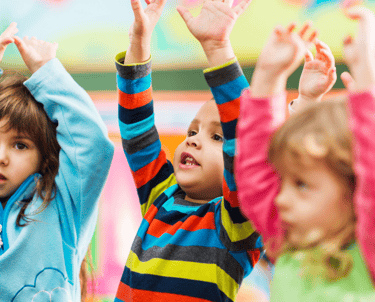 a group of children's hands up in the air