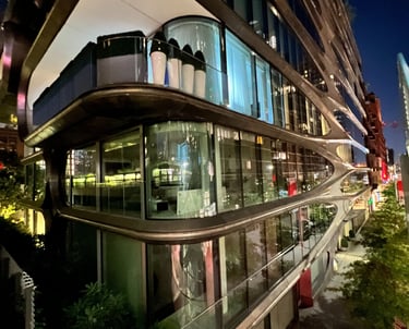 a building with a glass facade and a long glass balcony