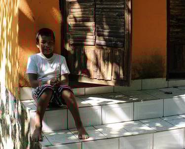 a young boy sitting on the steps of a house in Puerto Vallarta
