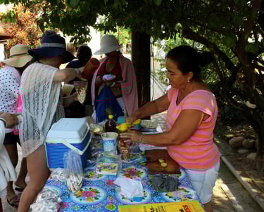 a woman is preparing to serve fruit to the tourists