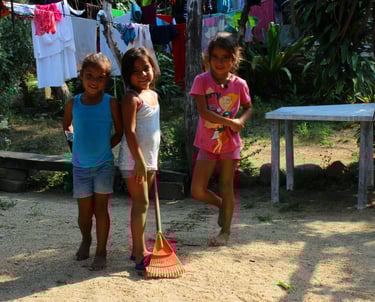 three young children playing with a broom in Puerto Vallarta